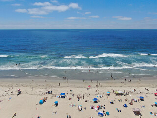 Fototapeta na wymiar Aerial view of people at the beach during blue summer day. Pacific Beach in San Diego, California 