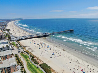 Aerial view of people at the beach near the pier with during blue summer day. Pacific Beach in San Diego, California 