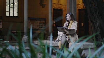 Student writing in notebook at college. Businesswoman making notes in notepad