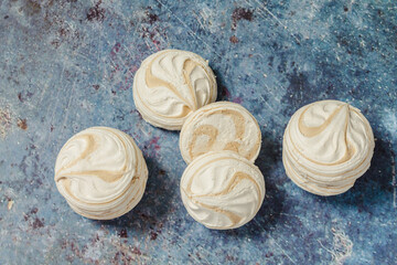 White marshmallows with coffee on a blue metal background..Free space for text.Top view.Holiday and festive food concept