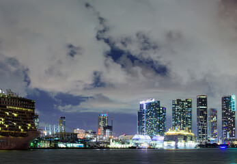 Night view of cruise liners near Miami Port. Miami downtown. Cruise ship in the Port of Miami at sunset with multiple luxury yachts.