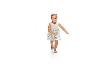 Happy child, little and emotional caucasian girl jumping and running isolated on white background. Looks happy, cheerful, sincere. Copyspace for ad. Childhood, education, happiness concept.
