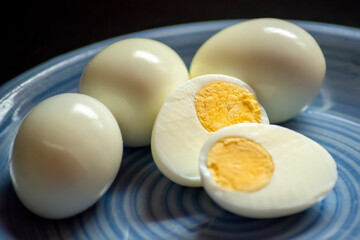 Hard boiled eggs on blue plate and dark background