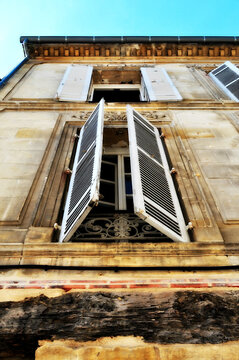 Ventana de edificio antiguo, contraventanas abiertas.