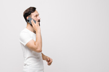  Pensive young man is using a mobile phone. space for text