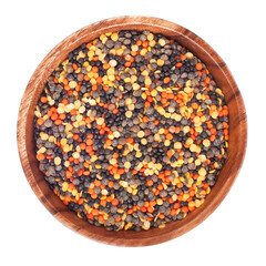 Heap of different lentils in the wooden bowl isolated on a white background. Top view.
