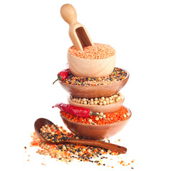 Stack bowls of different lentils and soy beans with red hot peppers isolated on a white background.
