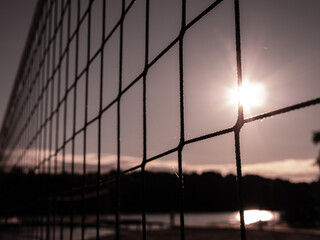 Volleyball net in the sand background close-up. The beach volleyball court is closed by the...