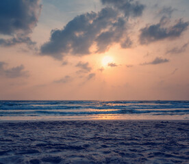 Obraz premium Dawn on the ocean. Sea with waves, sandy beach. Image with retro tone. Beautiful landscape