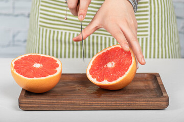 Cutting a grapefruit on a wooden board