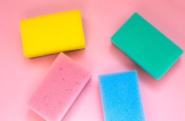 Colorful sponges for washing dishes on pink background. Artificial fiber not eco-friendly tool. Things for kitchen.