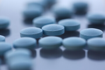 Macro photo of many white tablets that being on glance surface, useful for human health