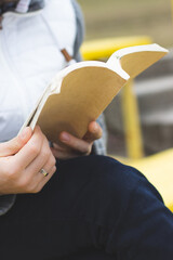 A man is reading a book in the park. Enjoyable rest in the park. Book reading.