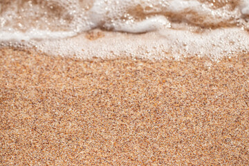 foaming sea wave on a sandy beach. Summer sea background