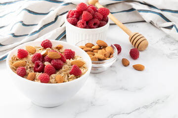 Healthy breakfast. Bowl with oatmeal with fresh raspberries and almonds. Copy space