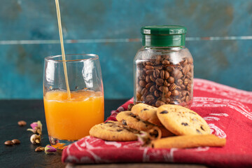 Fototapeta na wymiar Cookies with chocolate drops served with a glass of orange juice
