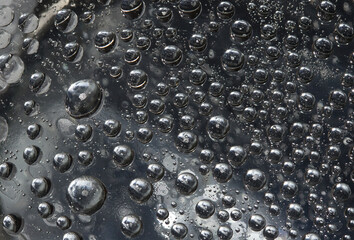 Silver metal spheres are located on a mirror ice surface. Close up. Space abstraction. 