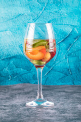 A glass of cocktail with mint and fruits