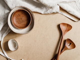 Modern minimalist ceramics set with a linen cloth over kraft paper background. Natural products or food concept, top view, flat lay.