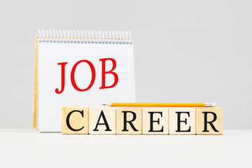 Job and Career text on notepad with pencil on grey background. Planning a career or job hunt or...