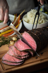 carving roast beef with knife and fork - obrazy, fototapety, plakaty
