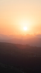 sunset between clouds and mountains in summer