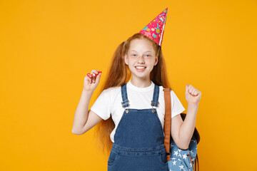 Happy fun redhead school teen kid girl 12-13 years old in birthday hat white t-shirt blue uniform backpack celebrate isolated on yellow background children studio portrait Education lifestyle concept