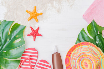 Flat lay composition with a summer hat and flip flops on a light background