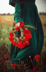 a wreath of poppies in the hands of a girl