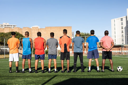 Multi ethnic team of male football players training at a sports field 