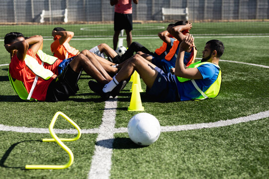 Multi ethnic team of male football players training at a sports field - Powered by Adobe