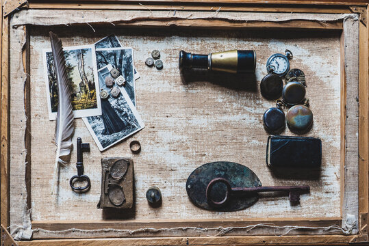 vintage antique accessories in a picturesque 18th century chamber: black and white postcards, watches, binoculars, nib pen, glasses, ring, old key and notebook, top view 