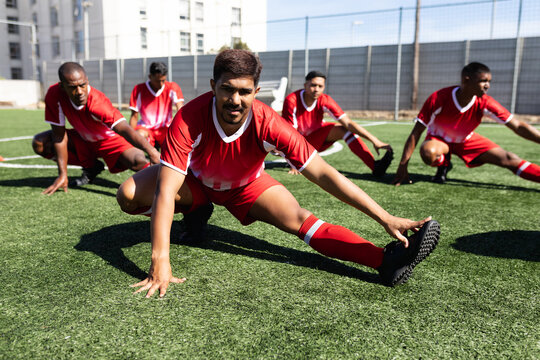 Multi ethnic team of male football players training at a sports field 