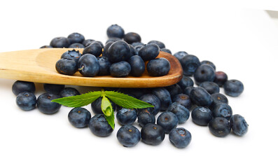 Blue berry and wooden spoon on white background 