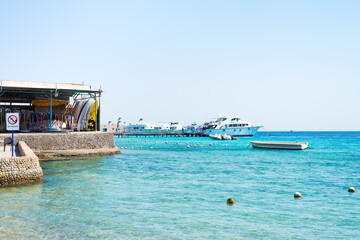 Seascape with stone coastline and parked boats.