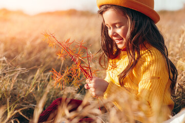 Delighted girl playing with grass in field