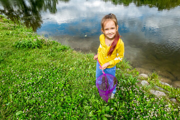 A girl with a net on the Bank of a river on a  summer day