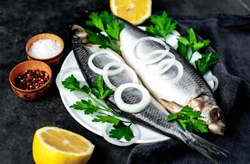 salted herring with onions and parsley on a stone background