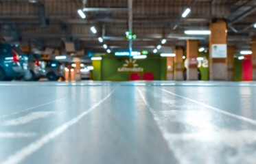 Parking lot cars blurred. Car lot parking space in underground city garage. Empty road asphalt background in soft focus. Industrial Shed or Parking Lot.