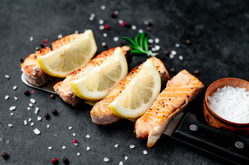 
grilled salmon slices over a meat knife on a stone background
