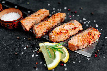 
grilled salmon slices over a meat knife on a stone background
