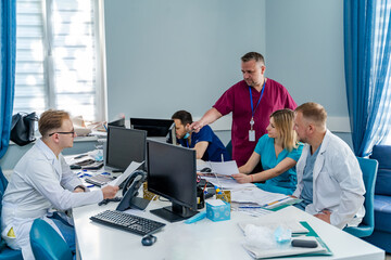 Obraz premium Team of dotors are sitting in medical office. Doctors discussing and dealing with health issues.