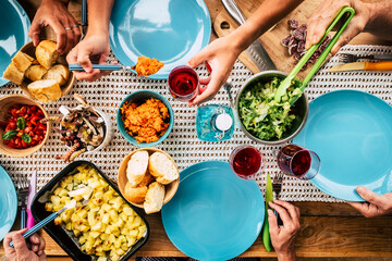Top vertical coloured view of table full of food and colors - decorated and celebration concept with people eating together in party or event family and friends meeting