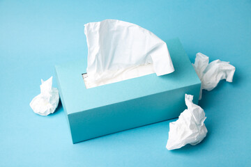 Cold and flu concept with a tissue box and crumpled tissues - obrazy, fototapety, plakaty