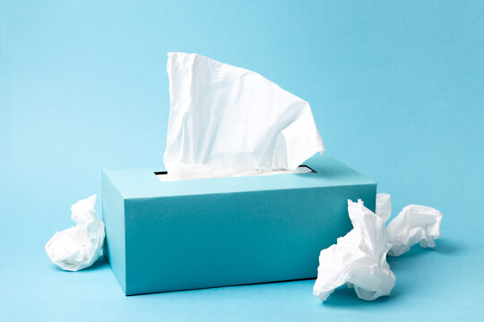Cold and flu concept with a tissue box and crumpled tissues