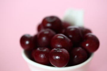 bowl of fresh juicy cherries macro close up on pik background