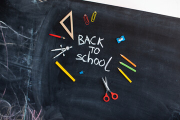 Back to school concept. Chalkboard background. Hand and education tools. 