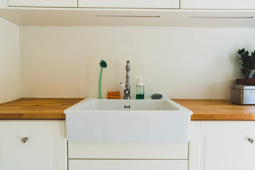 Fototapeta na wymiar Kitchen sink with utensils: sponge, soap and brush.
