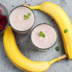 Two glasses of summer smoothie with raspberries and banana