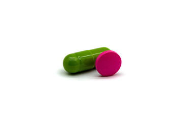 A green medicinal capsule and one pink tablet